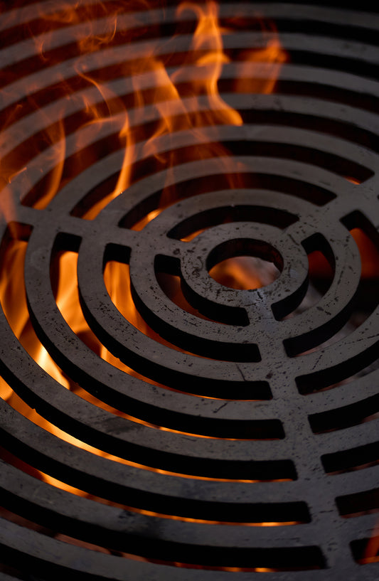 Runder OFYR Grillrost über loderndem Feuer – Detailansicht