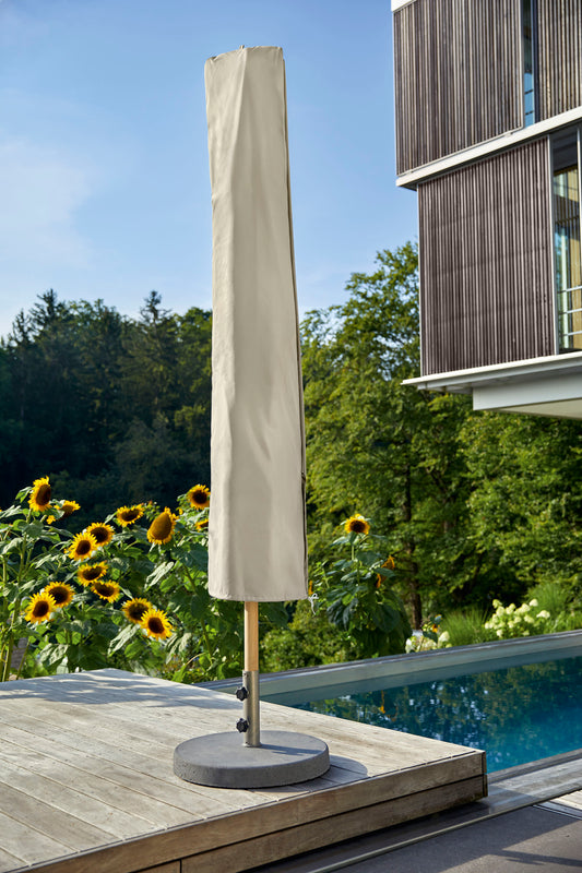Sonnenschirm mit heller Schutzhülle auf einer Terrasse