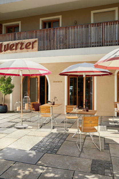 Weishäupl Pagodenschirm mit Streifen in Pink-Bordeaux über Balcony Stühlen und Bistrotisch