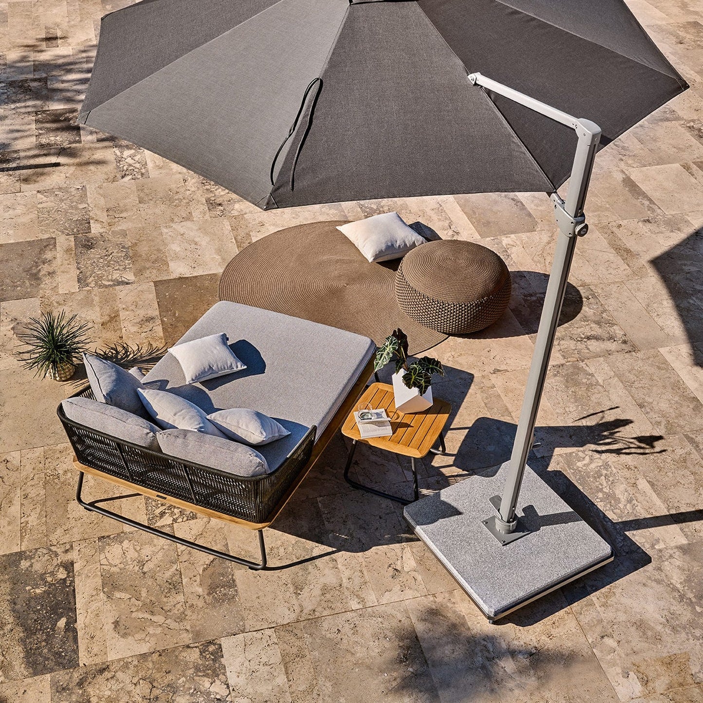 Freiarm-Bodenplatte mit Ampelschirm über Daybed auf der Terrasse