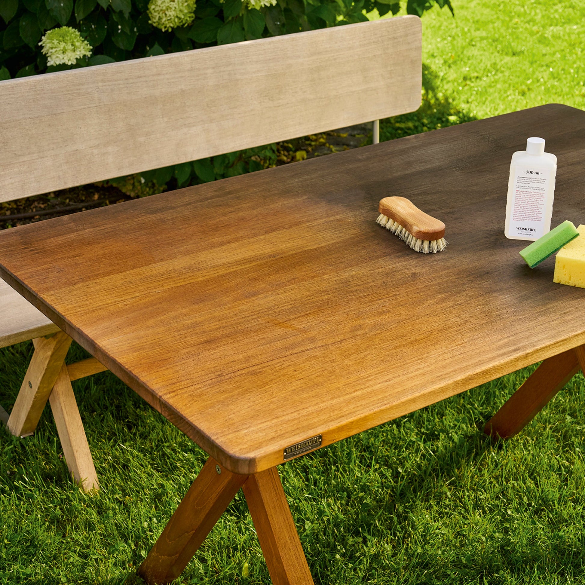 Teaktisch im Garten wird gereinigt und aufgefrischt