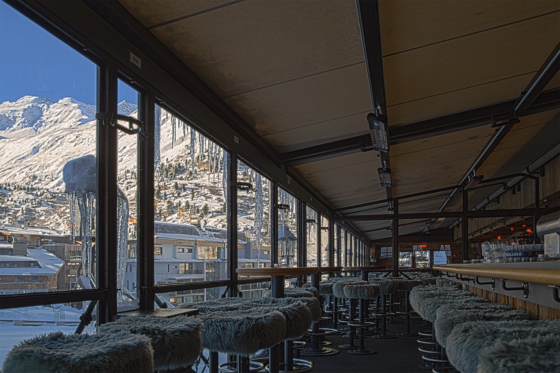 ExtremeLine HeatShine über einer überdachten Terrasse mit Sitzgruppe