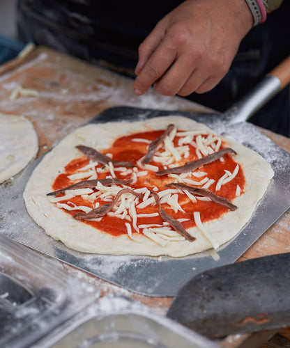Frisch belegte Pizza wird für den OFYR Pizza Oven vorbereitet