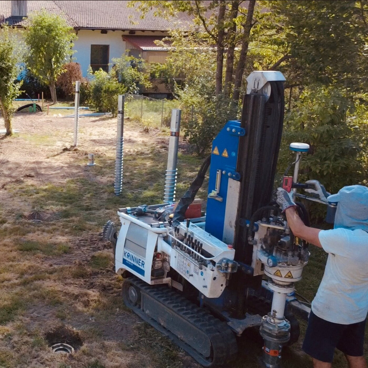 Krinner Schraubfundamente beim Eindrehen auf einem Grundstück