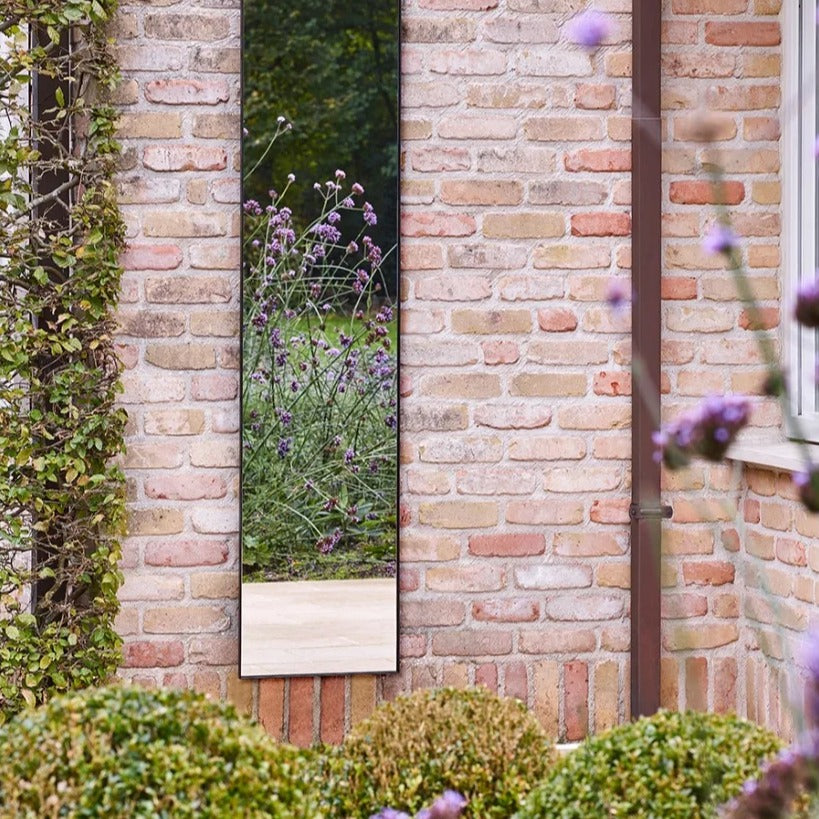 Outdoor-Spiegel Lucka Hall von Deknudt Mirrors an einer Ziegelwand